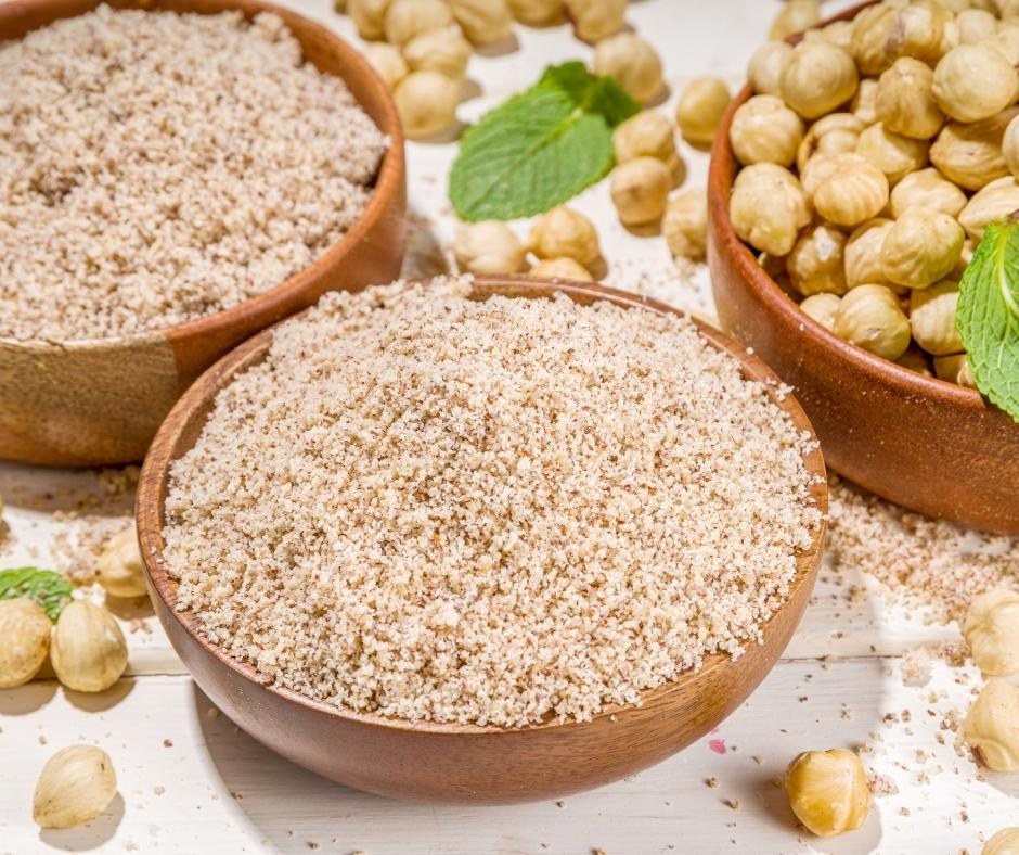 Hazelnut flour and hazelnuts in bowls