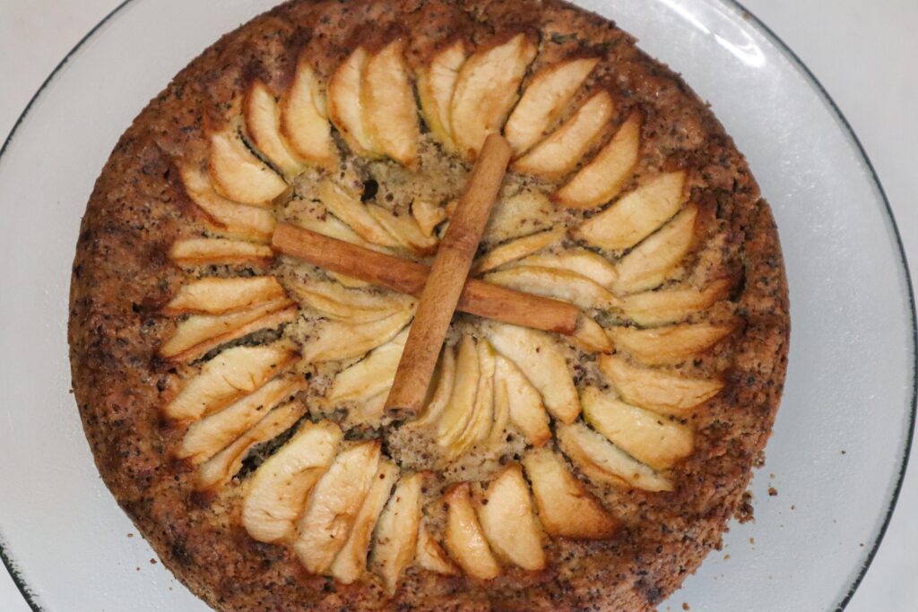 Hazelnut apple zucchini cake on a cake stand.