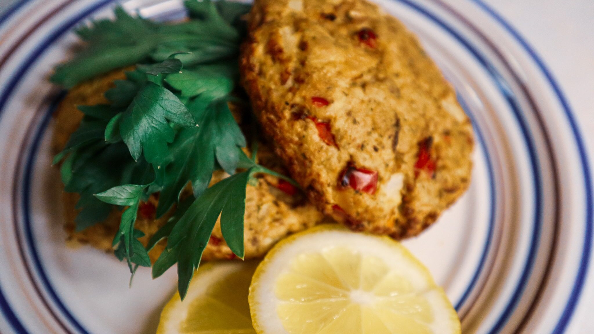 Air fryer lemon patties garnished on a plate with lemon slices and parsley.