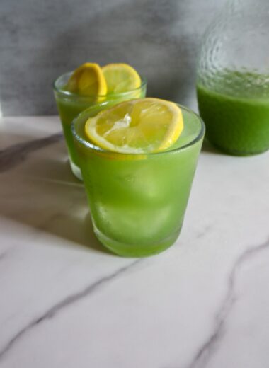 Refreshing coconut cucumber water in 2 glasses garnished with lime.