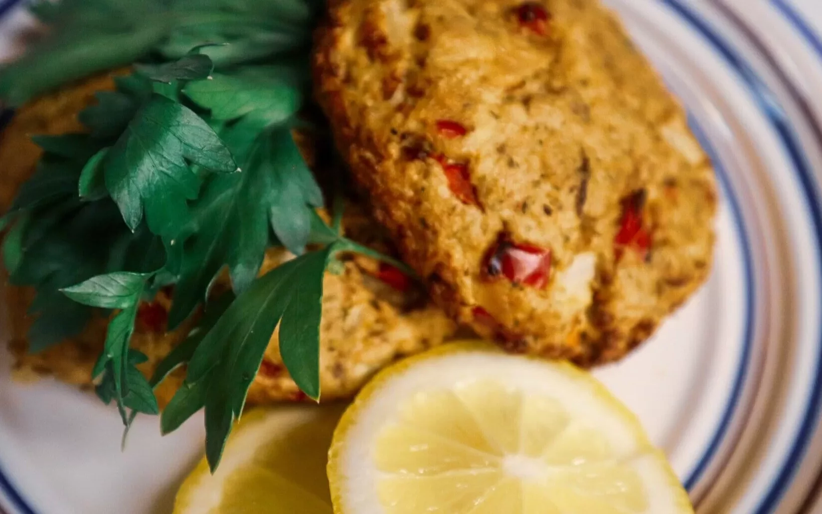 Air fryer lemon patties garnished on a plate with lemon slices and parsley.