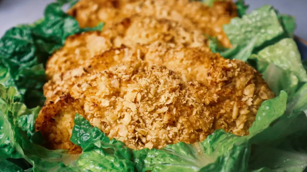 Air fryer sour cream and onion chicken on a plate garnished with Romaine lettuce.