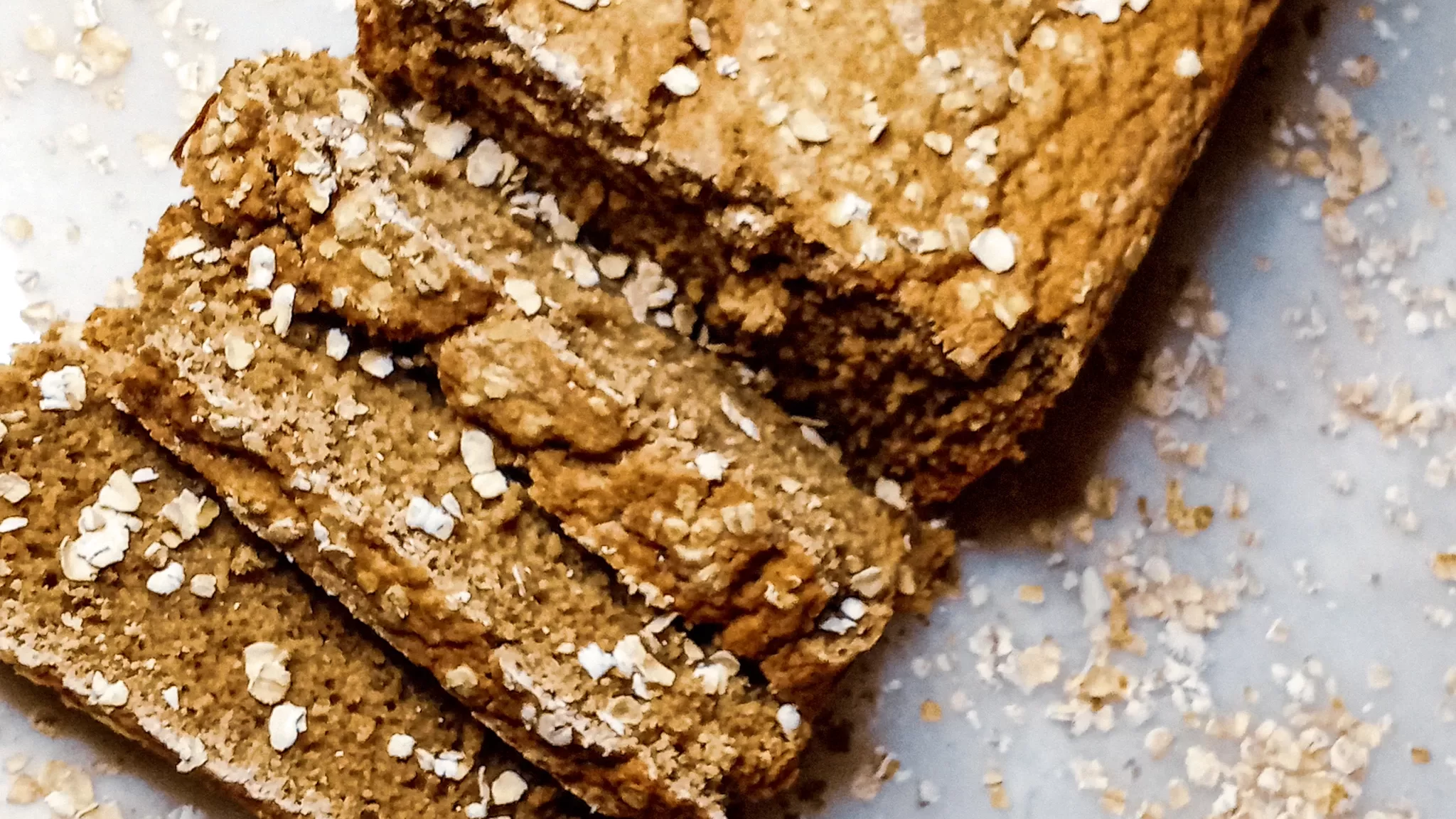 Sliced spiced oat flour bread on a tile.