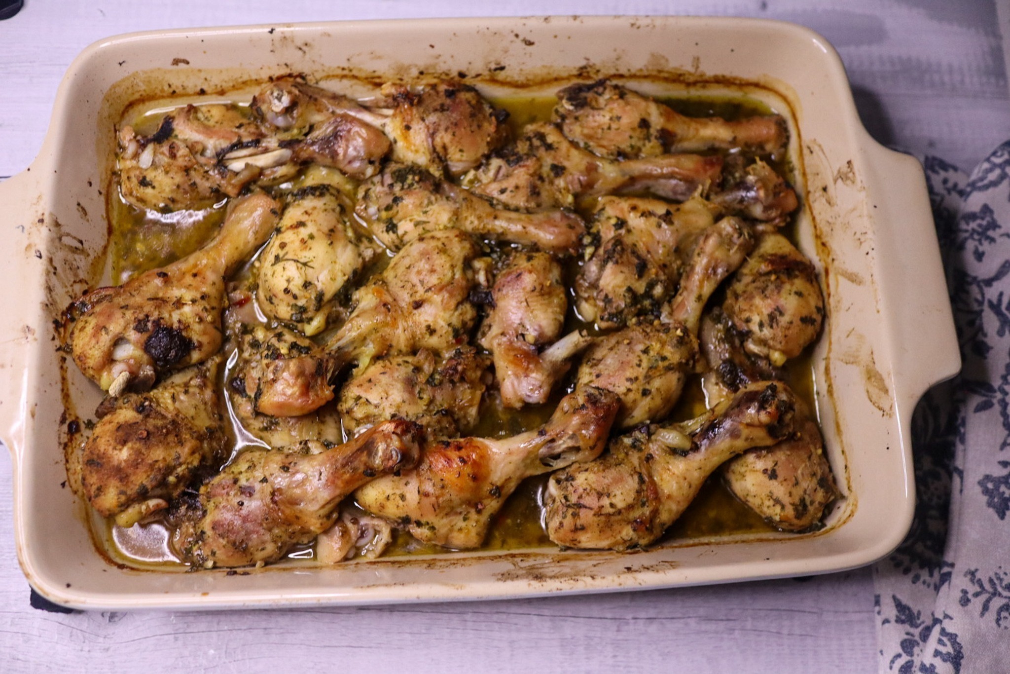Baked lemon parsley chicken legs in a baking dish.