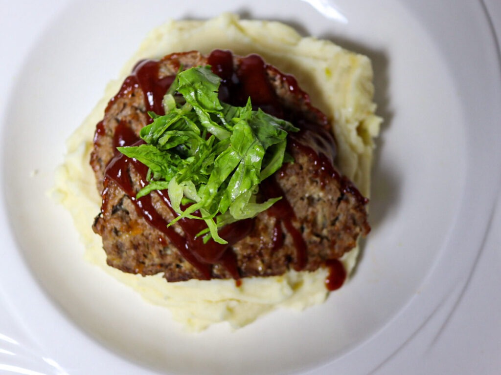 Gluten-free meatloaf with cranberry glaze served with pashed potatoes.