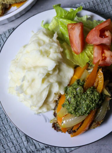 Cheesy pesto chicken served with mashed potatoes and a side salad.