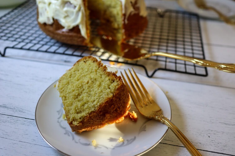 A slice of almond paste cake on a plate with a fork.