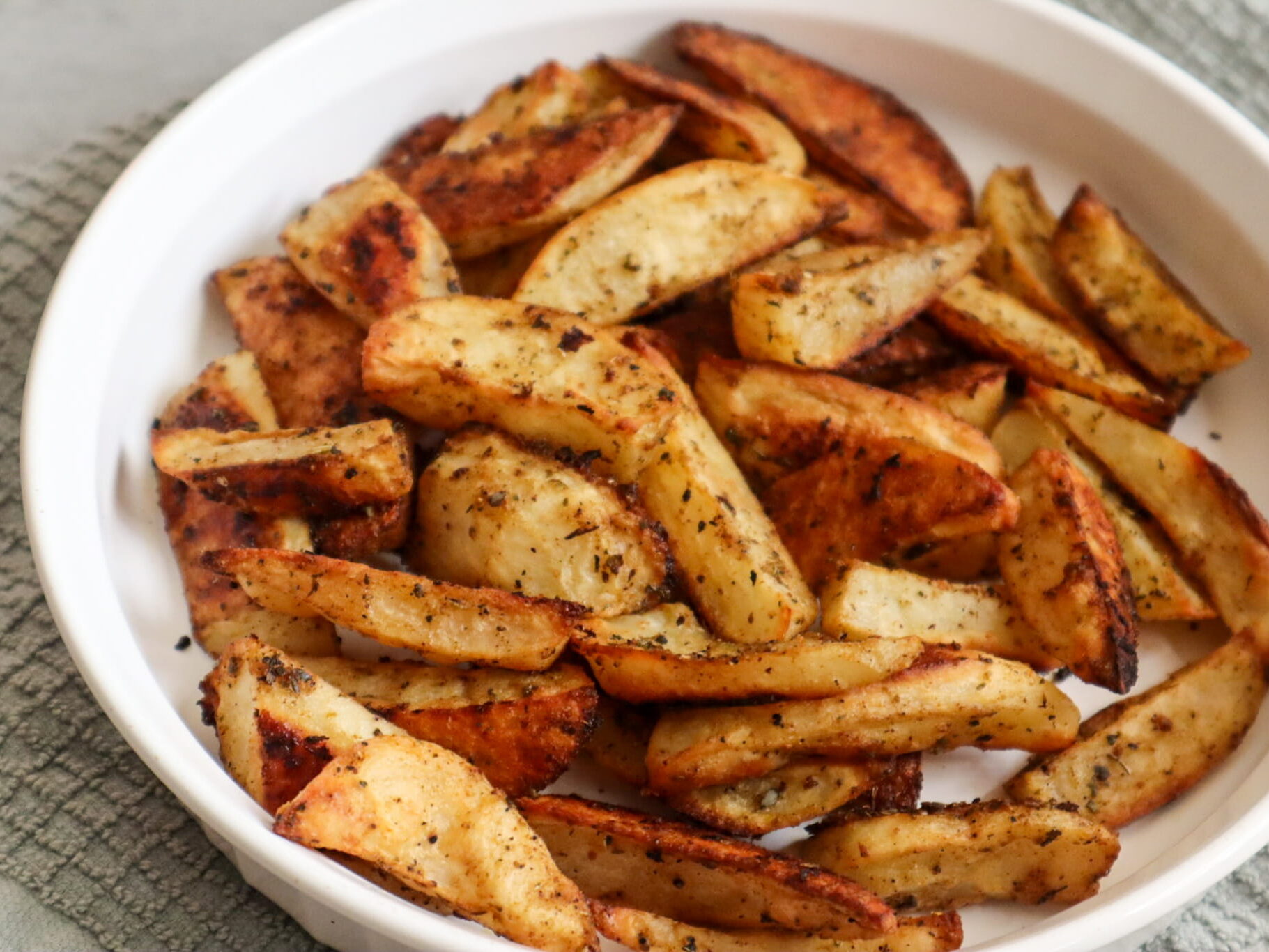 Roasted potato wedges in a serving dish.
