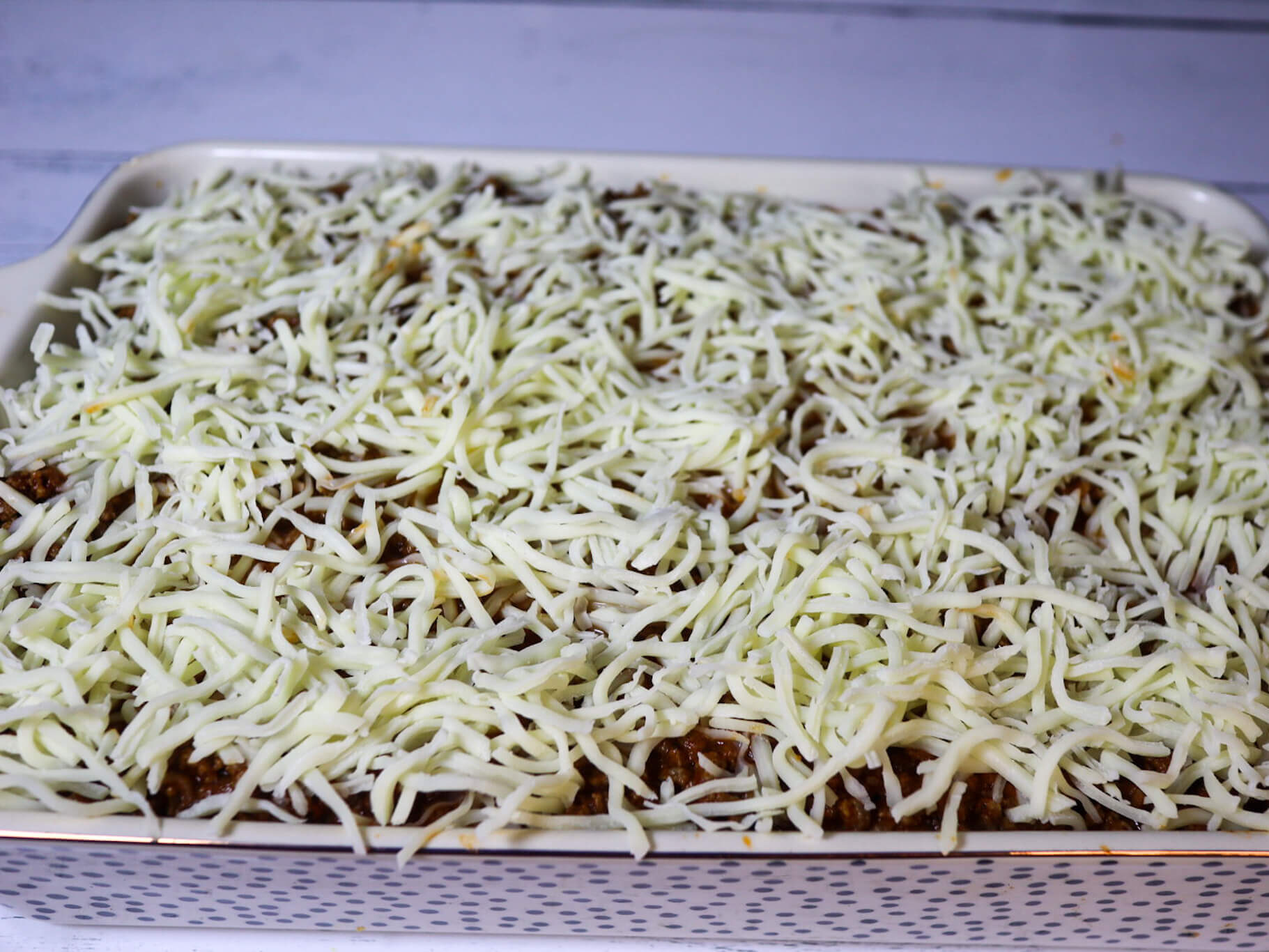Sprinkling the cheese on top of the pasta bake.